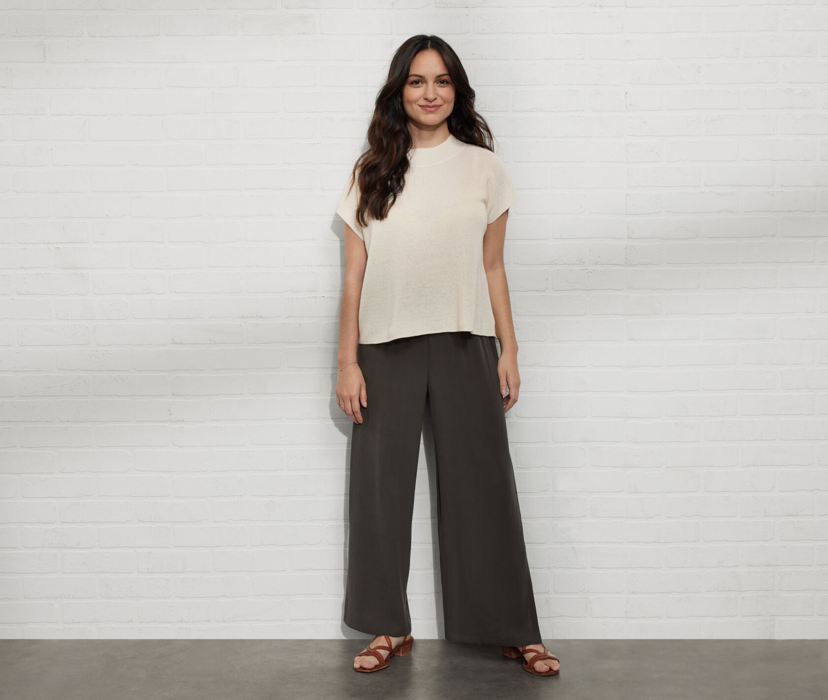 Petite woman wearing a boxy top and high-waisted pants.