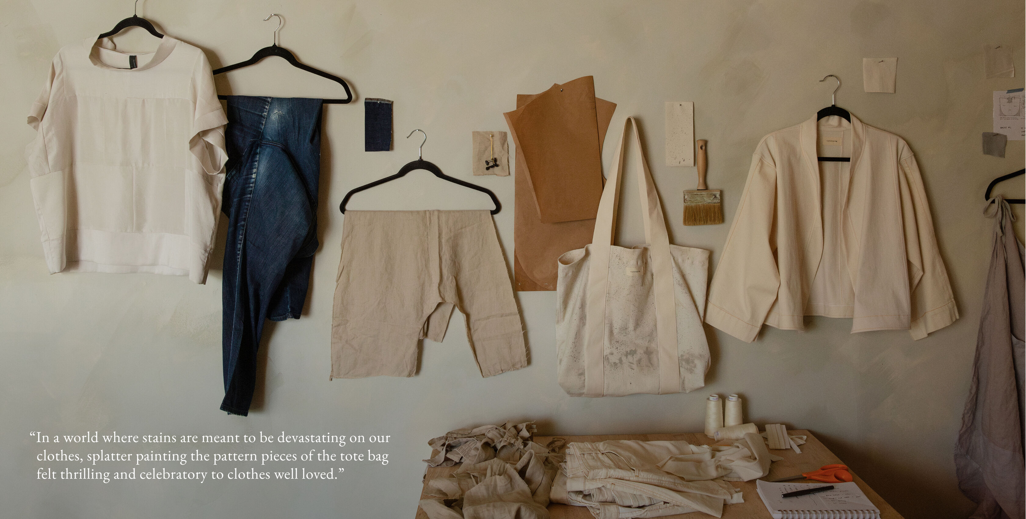 The finished pieces included a silk top, white denim jacket, and splatter paint tote hang on the wall of Elijah's store. The finished pieces included a silk top, white denim jacket, and splatter paint tote hang on the wall of Elijah's store.