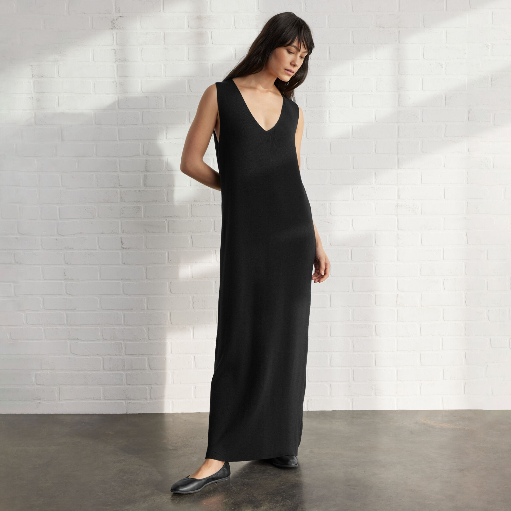 Woman wearing secondhand black maxi dress. 