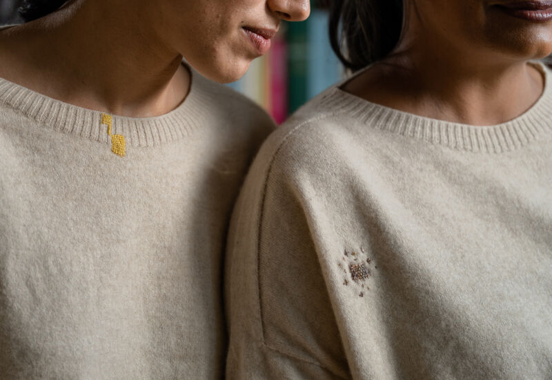 Women wearing sweaters with visible mending.