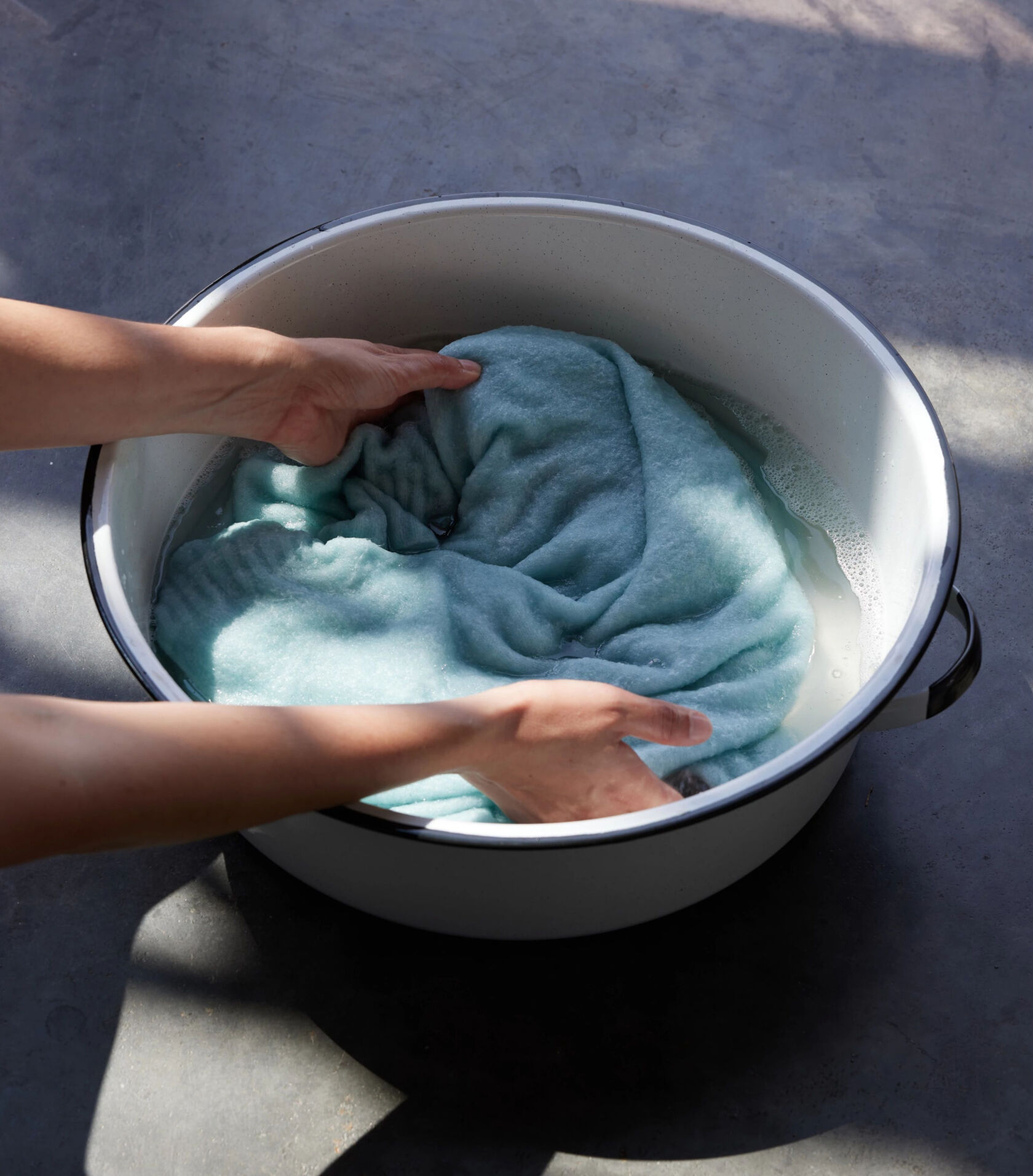 Woman hand washing a cashmere sweater.