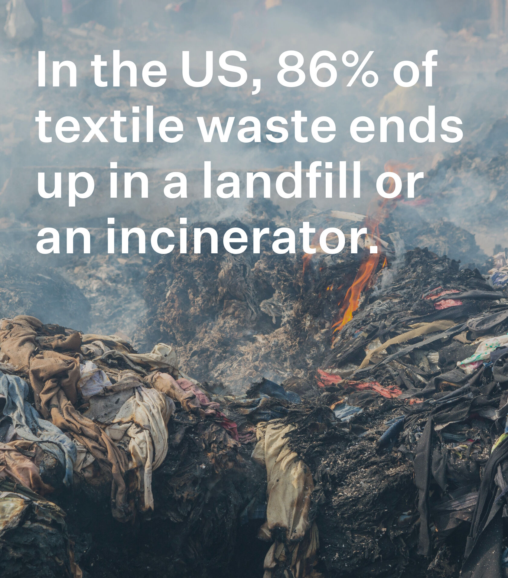 Clothing and textiles being burned n a landfill.