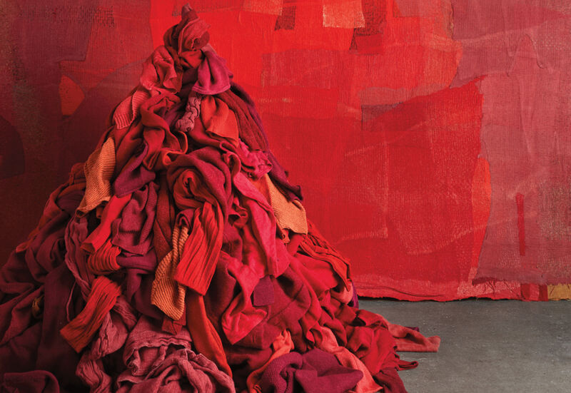 Pile of red EILEEN FISHER clothes against a red backdrop.