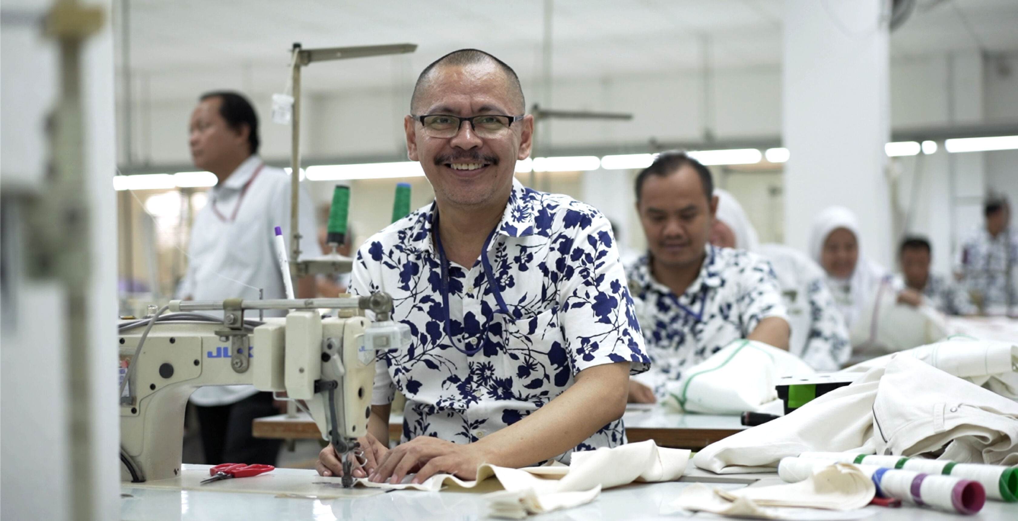 Man sewing at a garment factory.