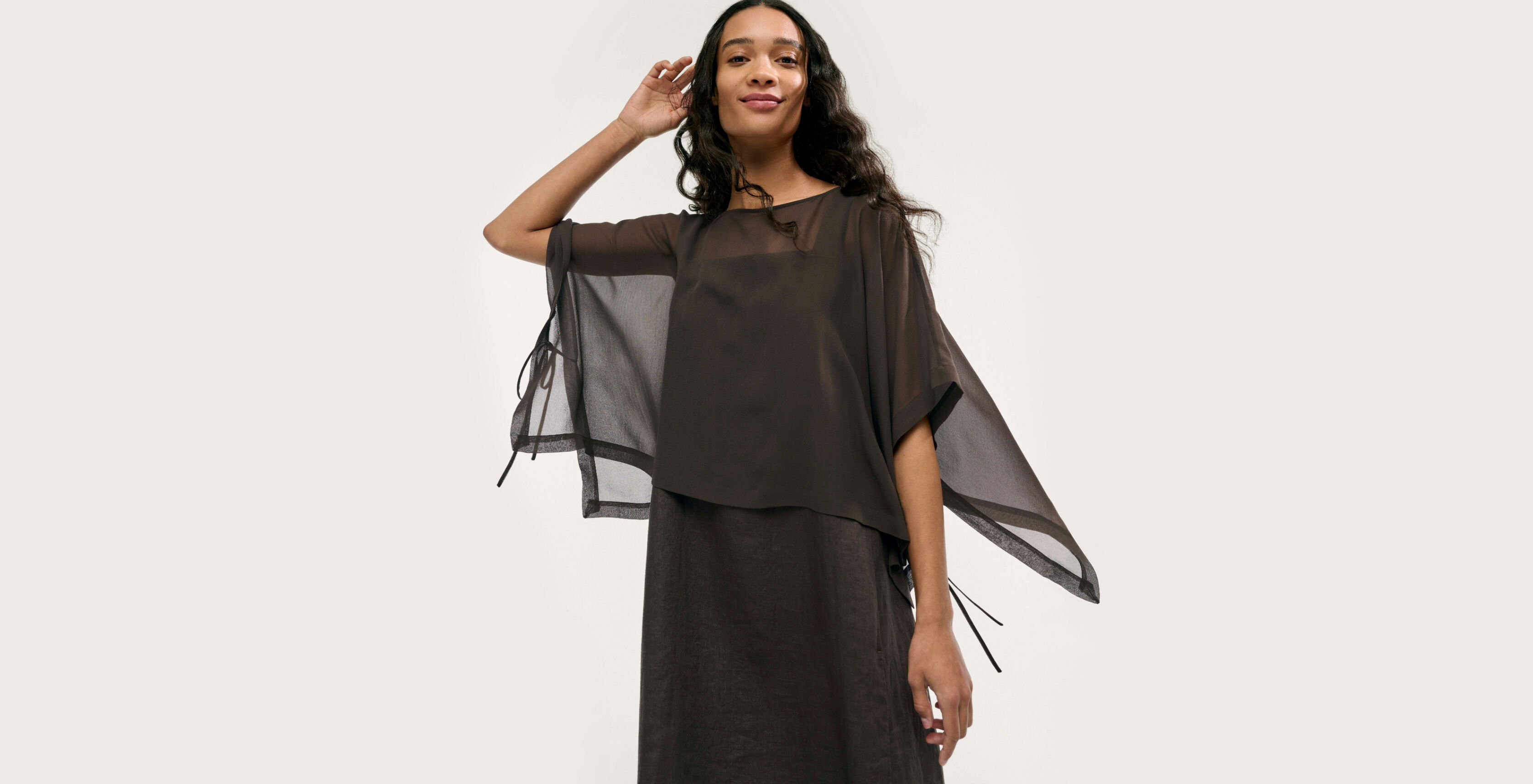 Woman wearing linen dress and silk poncho.