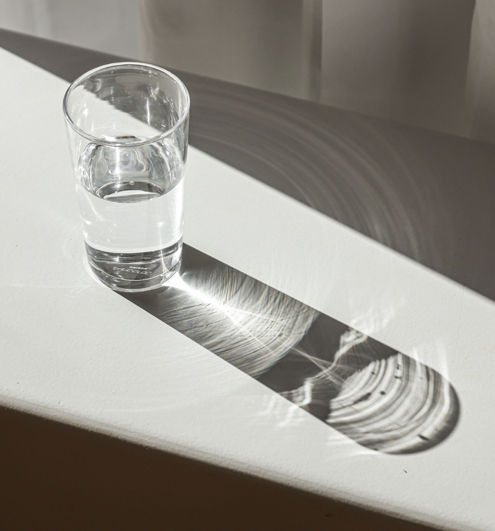 A glass of water on a white table.