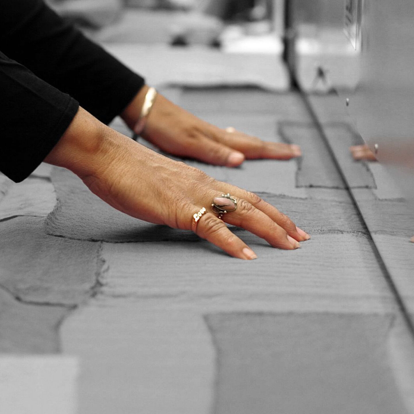 EILEEN FISHER employee feeding textile into needle-punch felting machine.