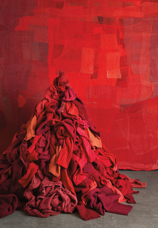 Pile of red EILEEN FISHER clothes against a red backdrop.
