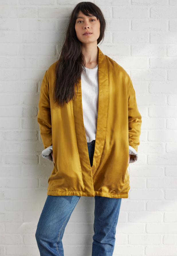 Woman wearing a timeless yellow silk jacket by EILEEN FISHER.