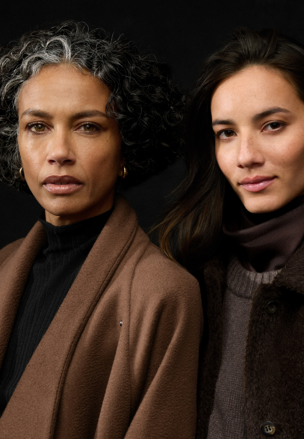 Portrait of two women with a black backdrop.